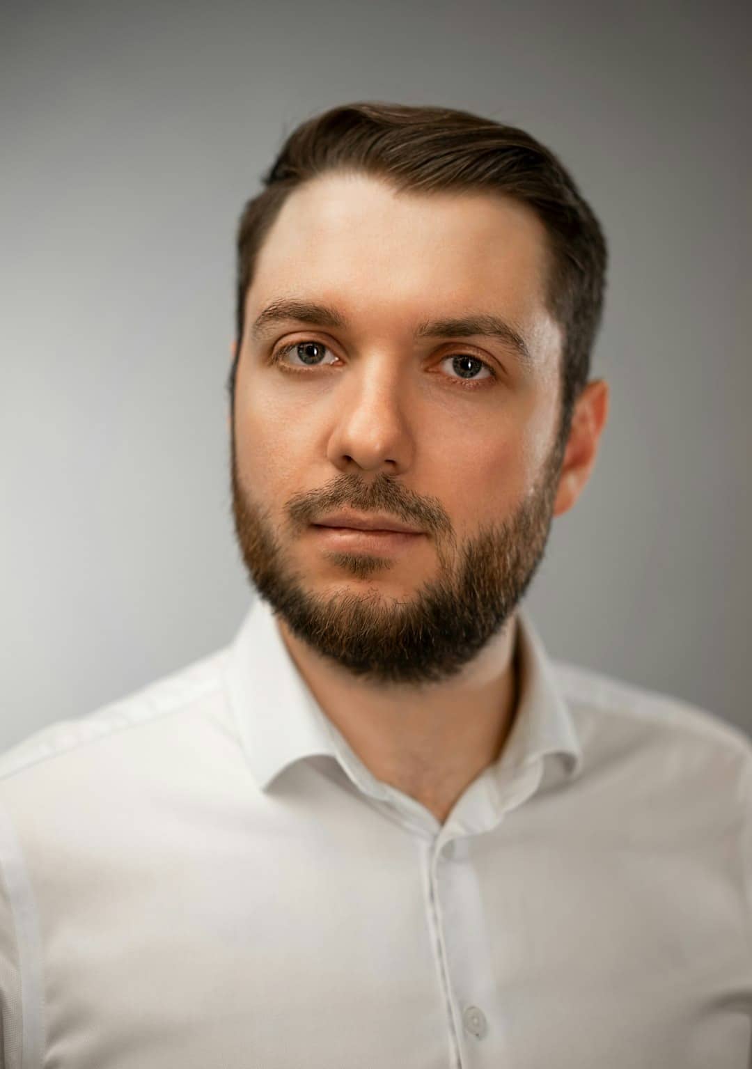 Man in white collared shirt looking forward.